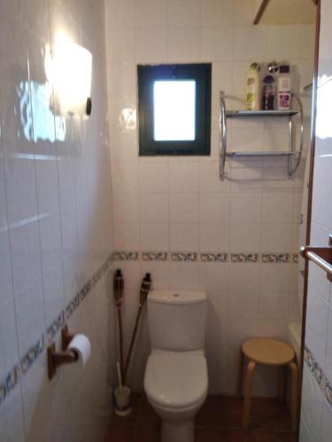 a small bathroom with a toilet and a window at La Casa de Trefacio in Trefacio