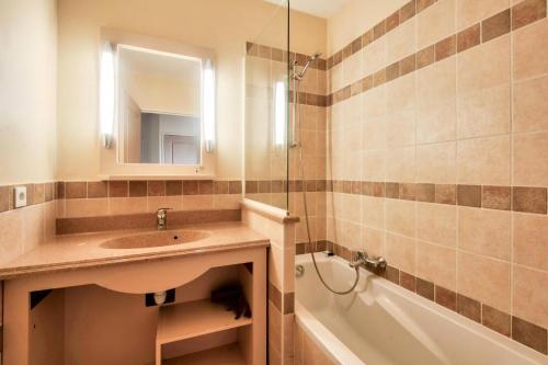 y baño con lavabo, bañera y espejo. en Les Coteaux de Pont Royal en Provence - maeva Home - Appartement 2 Pièces 4 30, en Mallemort