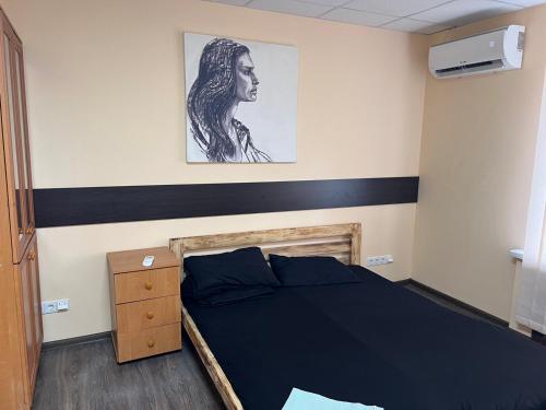 a bedroom with a bed and a picture on the wall at Hostel Krone GOK Zatishok in Kyiv