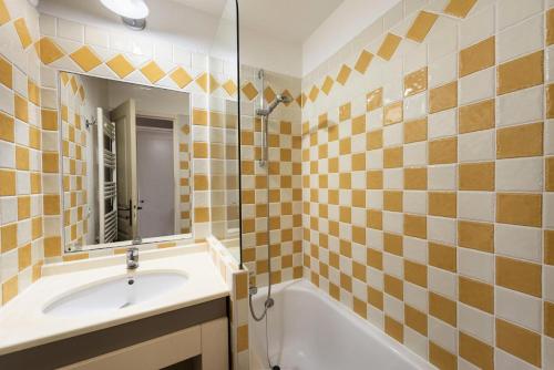 une salle de bain avec un lavabo, une baignoire et un miroir dans l'établissement Résidence Cannes Villa Francia - maeva Home - Appartement 2 Pièces 4 Personnes - Confort MAE-6043, à Cannes