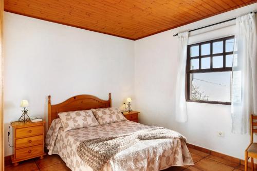 Schlafzimmer mit einem Bett und einem Fenster in der Unterkunft El Rincón in Tijarafe