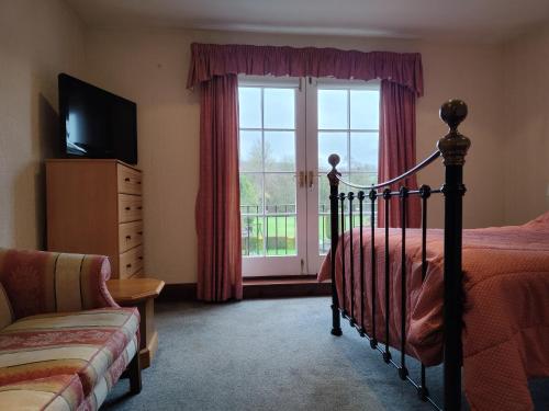 a bedroom with a bed and a window at The Golden Cup - Yoxall in Yoxall