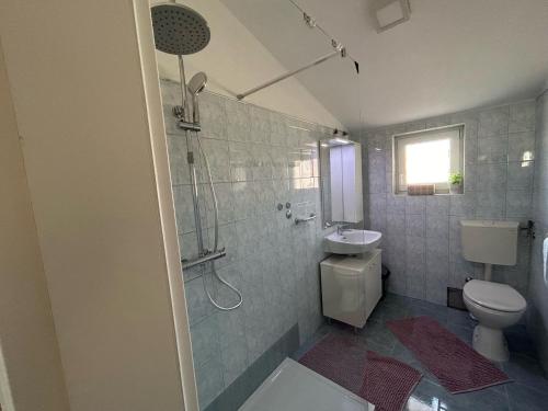 La salle de bains est pourvue d'une douche, de toilettes et d'un lavabo. dans l'établissement Apartments Katarina, à Poreč
