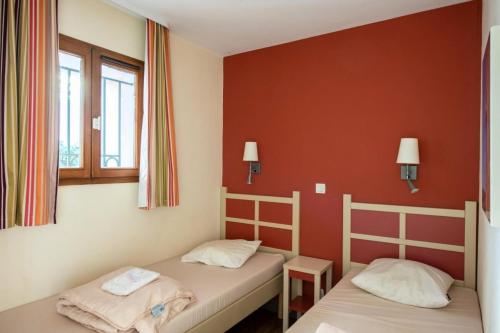 - 2 lits dans une chambre aux murs rouges dans l'établissement Résidence Cannes Villa Francia - maeva Home - Appartement 3 Pièces 6 Personnes - Confort MAE-6059, à Cannes