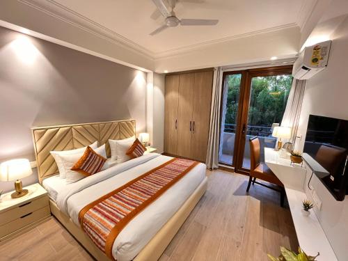 a bedroom with a bed and a desk and a television at Hotel South Ex Residency - South Ex near AIIMS Delhi - Couple Friendly in New Delhi