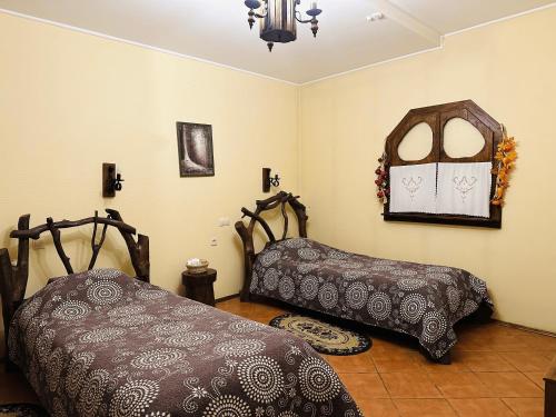a bedroom with two beds and a chandelier at Фільварок Кмитів in Kosharishche