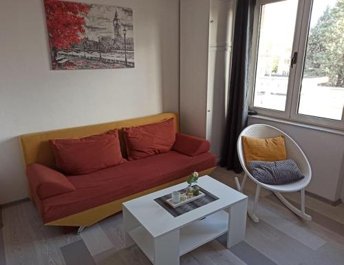 Una sala de estar con un sofá rojo y una mesa. en Apartment IVA, en Čitluk