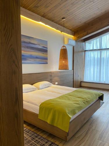 a bedroom with a large bed with a painting on the wall at Фільварок Кмитів in Kosharishche
