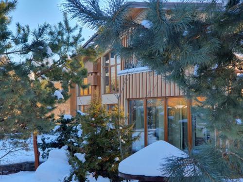 a house in the winter with snow on the trees at Фільварок Кмитів in Kosharishche