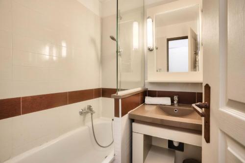 une salle de bain avec un lavabo, une baignoire et un miroir dans l'établissement Résidence Cannes Villa Francia - maeva Home - Appartement 2 Pièces 4 Personnes - Confort MAE-6060, à Cannes
