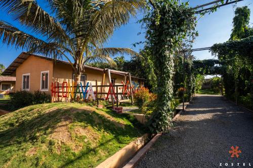 a house with a palm tree next to a driveway at Zostel Plus Lonavala in Lonavala
