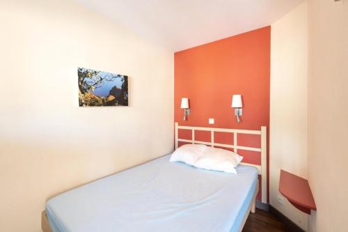 Ce lit se trouve dans un dortoir aux murs orange. dans l'établissement Résidence Cannes Villa Francia - maeva Home - Appartement 2 Pièces 4 Personnes - Budget MAE-6120, à Cannes