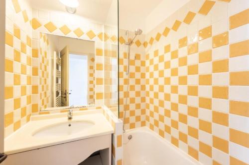 une salle de bain avec une baignoire, un lavabo et un miroir dans l'établissement Résidence Cannes Villa Francia - maeva Home - Appartement 2 Pièces 4 Personnes - Budget MAE-6120, à Cannes