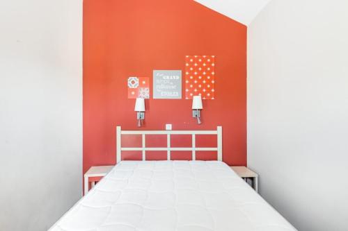 une chambre avec un lit avec un mur orange dans l'établissement Résidence Cannes Villa Francia - maeva Home - Appartement 2 Pièces 6 Personnes - Budget MAE-6123, à Cannes