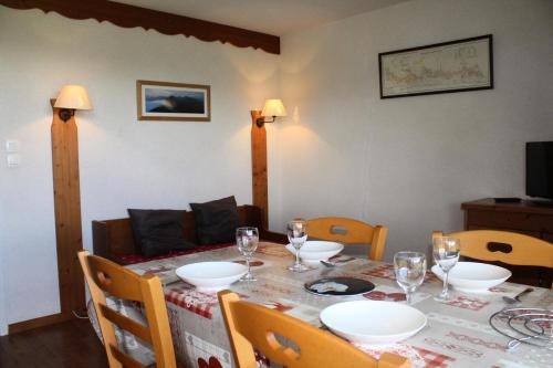 - une table à manger avec des assiettes et des verres à vin dans l'établissement Résidence La Marmotte La Crete Du Berger - APPARTEMENT 6 PERSONNES RDC BELLE VUE! MAE-9044, à Saint-Étienne-en-Dévoluy