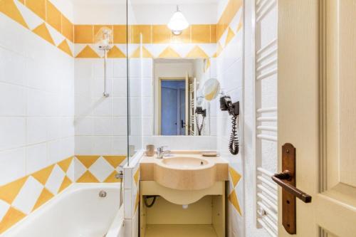une salle de bain avec un lavabo, une baignoire et un miroir dans l'établissement Résidence Cannes Villa Francia - maeva Home - Appartement 2 Pièces 6 Personnes - Sélection MAE-6133, à Cannes