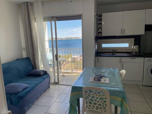 un salon avec un canapé et une table avec vue dans l'établissement Studio cosy 2 couchages à 50m de la plage avec vue sur l'étang - FR-1-680-2, à Balaruc-les-Bains