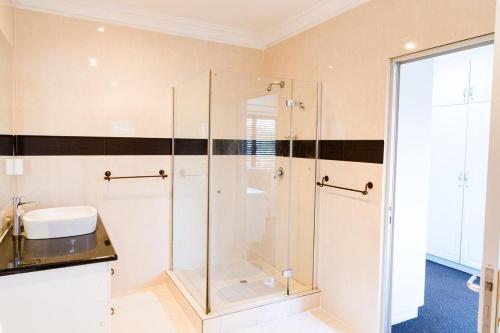bagno con doccia in vetro e lavandino di Villa 37 on Westridge a Durban