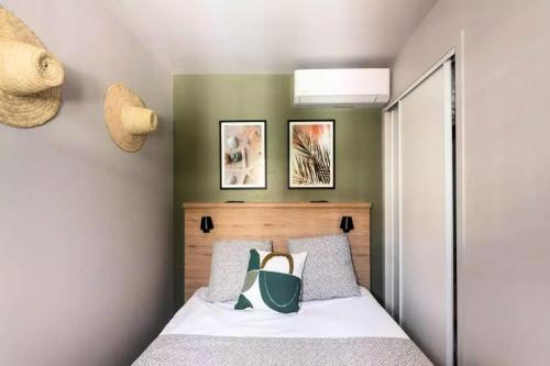 une chambre avec un lit avec une tête de lit et deux tableaux dans l'établissement Résidence Cannes Villa Francia - maeva Home - Appartement 2 pièces 6 personnes avec très belle vue mer - Prestige - super Home MAE-6260, à Cannes