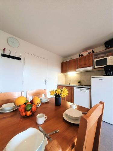 une cuisine avec une table en bois et des plaques de cuisson. dans l'établissement Résidence Les Toits Du Devoluy - 2 Pièces pour 4 Personnes MAE-9154, à Saint-Étienne-en-Dévoluy