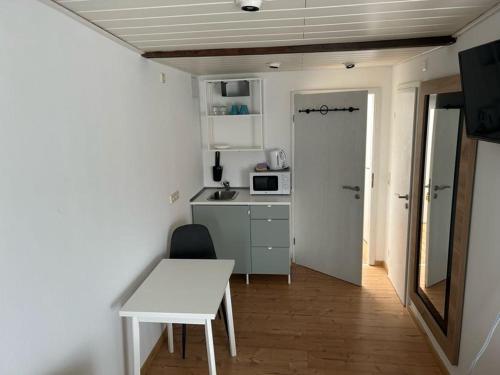 a small kitchen with a white table and a white table at Pension Sonnenschein in Halle an der Saale