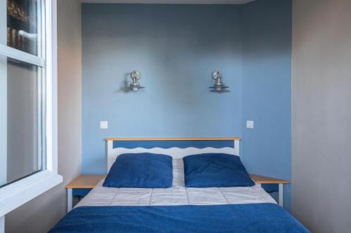 - une chambre bleue avec un lit et 2 oreillers bleus dans l'établissement Résidence Port Bourgenay - maeva Home - Appartement 2 pièces 5 personnes - Sélection MAE-6356, à Talmont-Saint-Hilaire