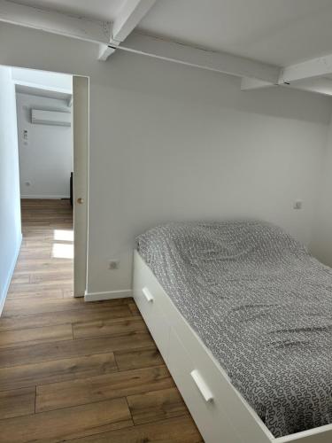 a bed in a room with a wooden floor at Logement entier Nîmes in Nîmes