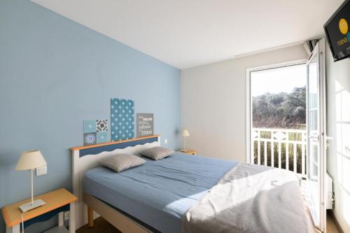 une chambre avec un lit et une grande fenêtre dans l'établissement Les Maisons de Port Bourgenay - maeva Home - Maison 3 pièces 6 personnes - Sélection MAE-6434, à Talmont-Saint-Hilaire