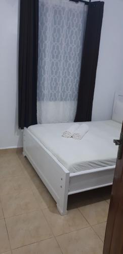 a white bed sitting in a room at Saas Homestay in Eldoret
