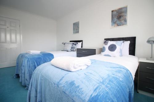 two beds in a room with blue and white at Chartwell Grove (Spacious 7 BR with FREE parking) in Nottingham