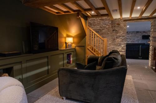ein Wohnzimmer mit einem Stuhl und einem TV in der Unterkunft The Cottage, Everards Farm in Chewton Mendip