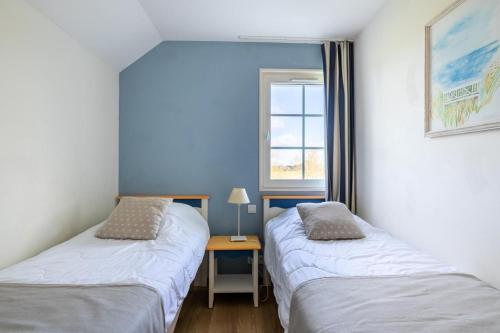 - 2 lits dans une chambre avec une table et une fenêtre dans l'établissement Les Maisons de Port Bourgenay - maeva Home - Maison 3 pièces 6 personnes - Sélection MAE-6435, à Talmont-Saint-Hilaire