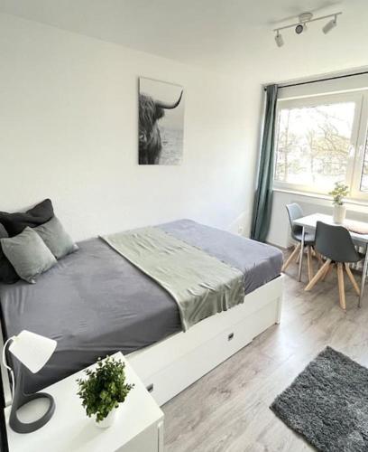 Schlafzimmer mit einem Bett, einem Tisch und einem Fenster in der Unterkunft 1-Raum-Apartment Nähe Hochschule Niederrhein in Mönchengladbach