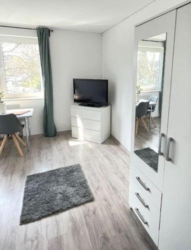 sala de estar con TV y espejo en 1-Raum-Apartment Nähe Hochschule Niederrhein, en Mönchengladbach
