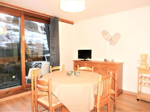 une salle à manger avec une table, des chaises et une télévision dans l'établissement Résidence Zodiaque - APPARTEMENT 3 PIECES 6 PERSONNES MAE-9374, au Corbier