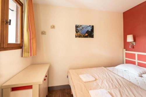 une petite chambre avec un lit et un bureau dans l'établissement Résidence Cannes Villa Francia - maeva Home - Appartement 2 pièces 4 personnes - Sélection MAE-6529, à Cannes