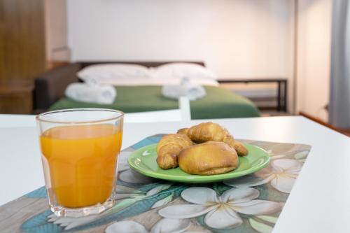 einen Tisch mit einem Glas Orangensaft und einem Teller Essen in der Unterkunft Vatican Apartment Borgo Pio in Rom