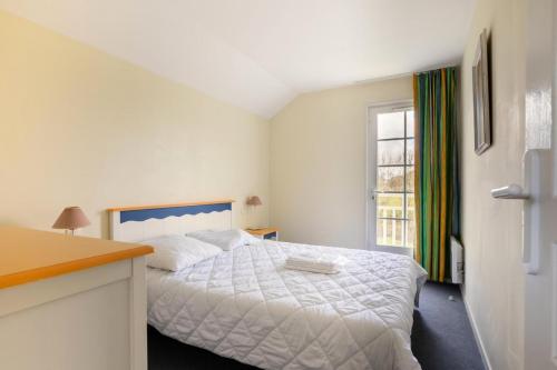 une chambre avec un lit blanc et une fenêtre dans l'établissement Les Maisons de Port Bourgenay - maeva Home - Maison 3 pièces 6 personnes - Confort MAE-6439, à Talmont-Saint-Hilaire