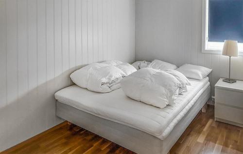 a bed with four pillows on it in a room at Beautiful Home In Rysstad With Kitchen in Rysstad