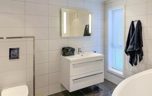 Baño blanco con lavabo y espejo en Beautiful Home In Rysstad With Kitchen, en Rysstad