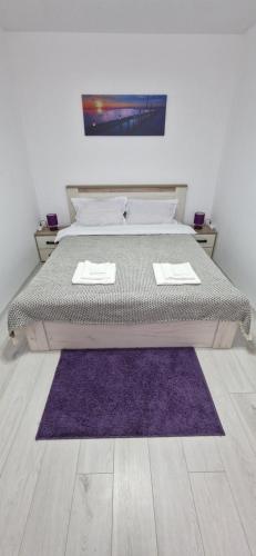 a bedroom with a bed with a purple rug at MELISSA APARTAMENT in Constanţa