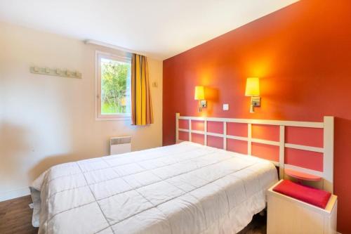 une chambre avec un grand lit aux murs orange dans l'établissement Résidence Les Parcs de Grimaud - maeva Home - Appartement 2 pièces 5 personnes - Confort MAE-6628, à Grimaud