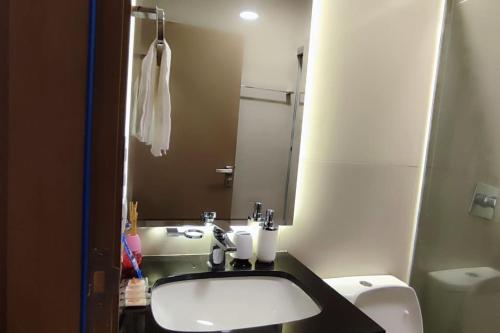 a bathroom with a sink and a toilet and a mirror at DEPARTAMENTO EN EQUIPETROL CON PISCINA - GYM Y PARQUEO GRATIS, CERCA DEL VENTURA MALL , LOS TAJIBOS, MANZANA 40 Y SUPERMERCADOS in Santa Cruz de la Sierra