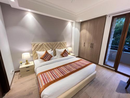 a bedroom with a large bed and a window at Hotel South Ex Residency - South Ex near AIIMS Delhi - Couple Friendly in New Delhi