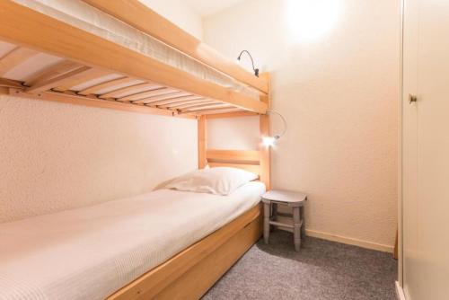 une petite chambre avec deux lits superposés et un tabouret dans l'établissement Résidence Orion - STUDIO CABINE 4/5 PERSONNES VUE PISTES MAE-9584, au Corbier