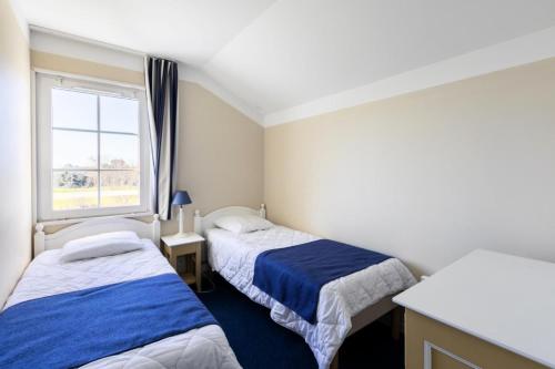 deux lits dans une petite pièce avec une fenêtre dans l'établissement Les Maisons de Port Bourgenay - maeva Home - Maison 3 pièces 6 personnes - Sélection MAE-6631, à Talmont-Saint-Hilaire