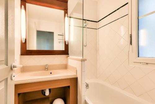 une salle de bain blanche avec un lavabo et une douche dans l'établissement Les Maisons de Lacanau les Pins - maeva Home - Maison 3 pièces 6 personnes - Prestige MAE-6632, à Lacanau