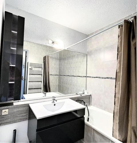 une salle de bain avec un lavabo, une baignoire et un miroir dans l'établissement Résidence Vanguard - Studio rénové · Pied des pistes · Balcon · WIFI gratuit MAE-9614, au Corbier