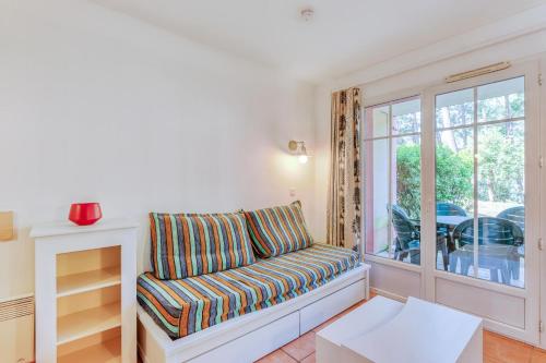 un salon avec un canapé et une fenêtre dans l'établissement Résidence Lacanau Les Pins - maeva Home - Appartement 2 pièces 5 personnes - Sélection MAE-6661, à Lacanau