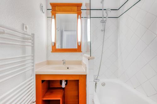 une salle de bain avec un lavabo, un miroir et une baignoire dans l'établissement Résidence Lacanau Les Pins - maeva Home - Appartement 2 pièces 5 personnes - Sélection MAE-6661, à Lacanau
